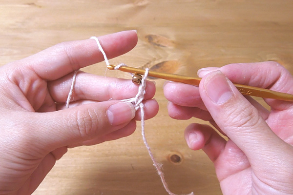 かぎ針編み 立ち上がりの3目を編み、次のくさり1目にビーズを編み込みます