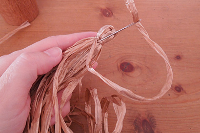 ⑩糸端をとじ針に通し、結び目にくぐらせます