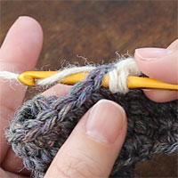 こま編み2目一度[4] となりの目に針を入れたら、また糸をかけて引き出します。