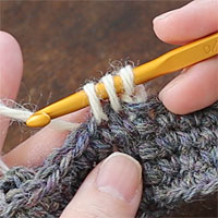 こま編み2目一度[5] 糸を引き出すと、かぎ針に3つのループがかかった状態になります。