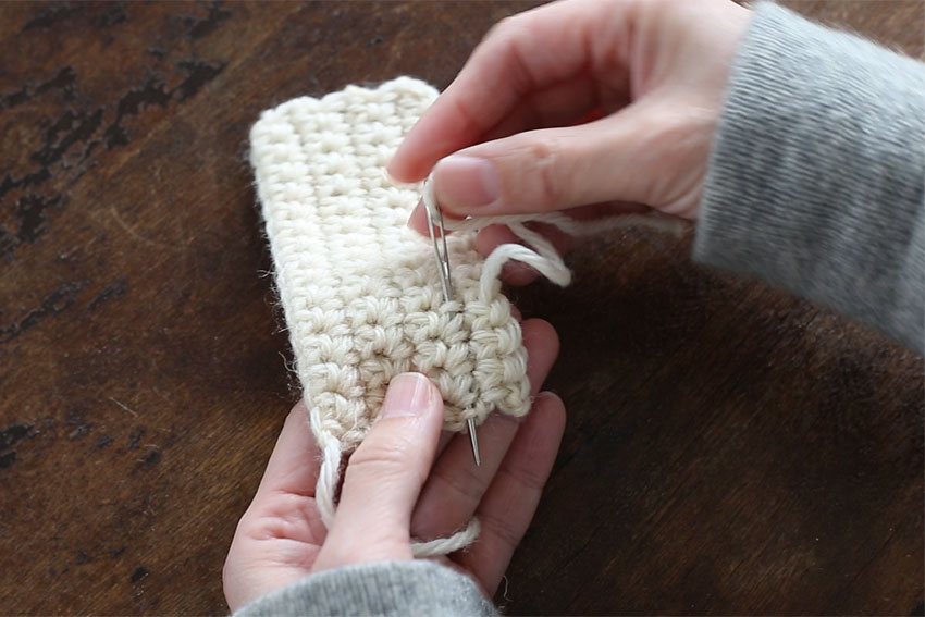 [3] 糸が出ているところからUターンするように、近くの編み地にまた2～3cm針をくぐらせます。