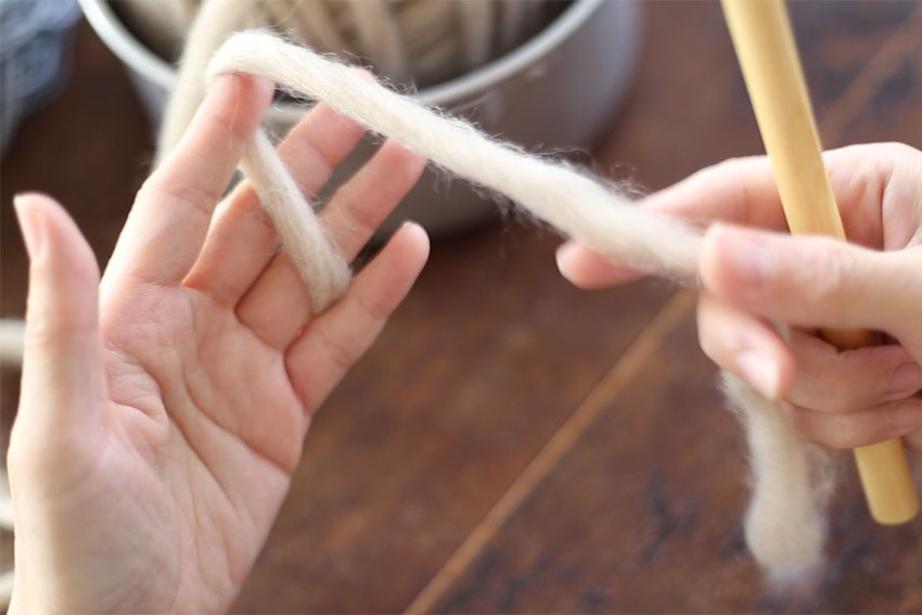 糸の持ち方[1] 左手の小指と薬指で毛糸をはさみ、人差し指にかけます。