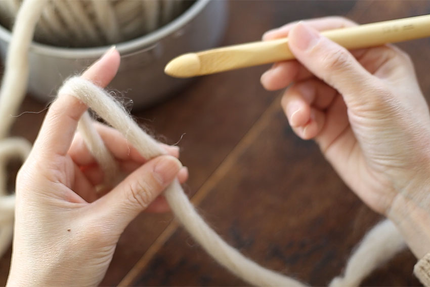 糸の持ち方[2] 手前に持ってきた糸端を、中指と親指で押さえます。