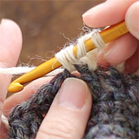 長々編み2目一度[2] 糸をかけて引き出しました。また糸をかけ、針先に近い2つのループをくぐらせます。