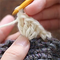 前段の目を束にすくって長編み5目編む[6] 同じところに針を入れて、4目めの長編みを編みました。