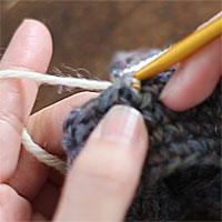 編み地の途中に糸をつける[3] 針に糸をかけて引き出します。