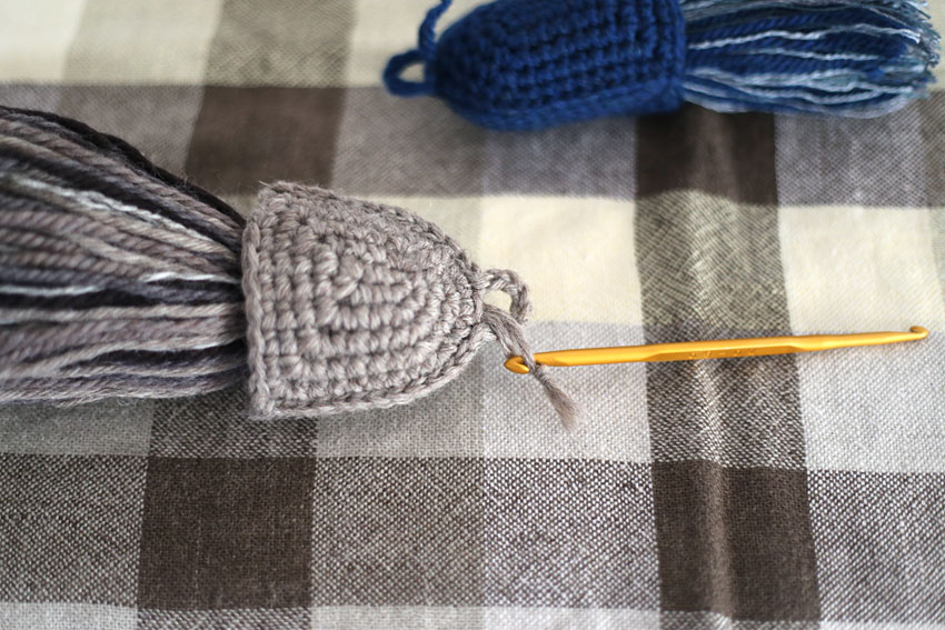 ふさのひもを引っぱって、持ち手部分にふさを収めます。