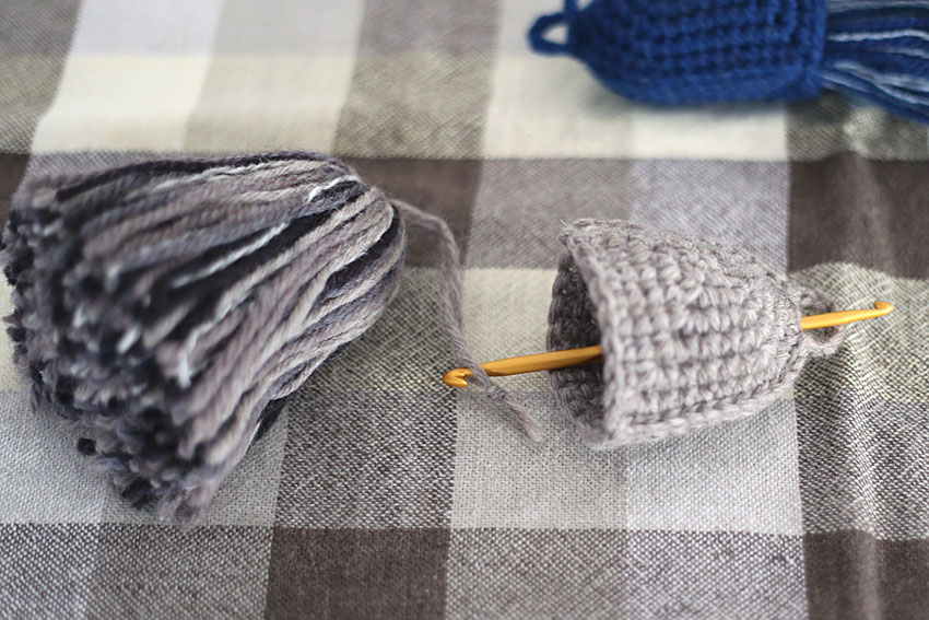 持ち手部分のてっぺんのすき間から針を入れて、ふさのひもを引っぱり出します。